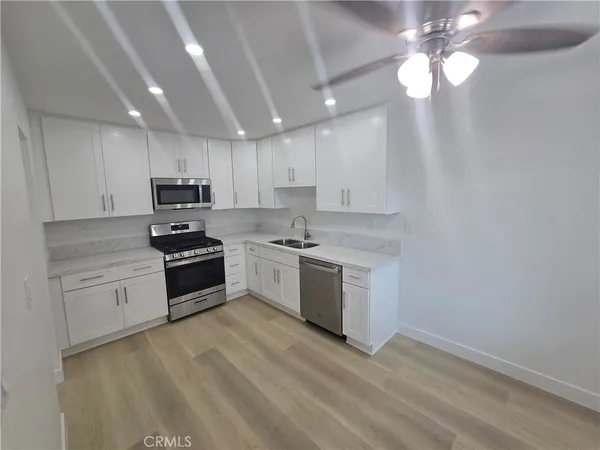 a kitchen with granite countertop white cabinets and stainless steel appliances