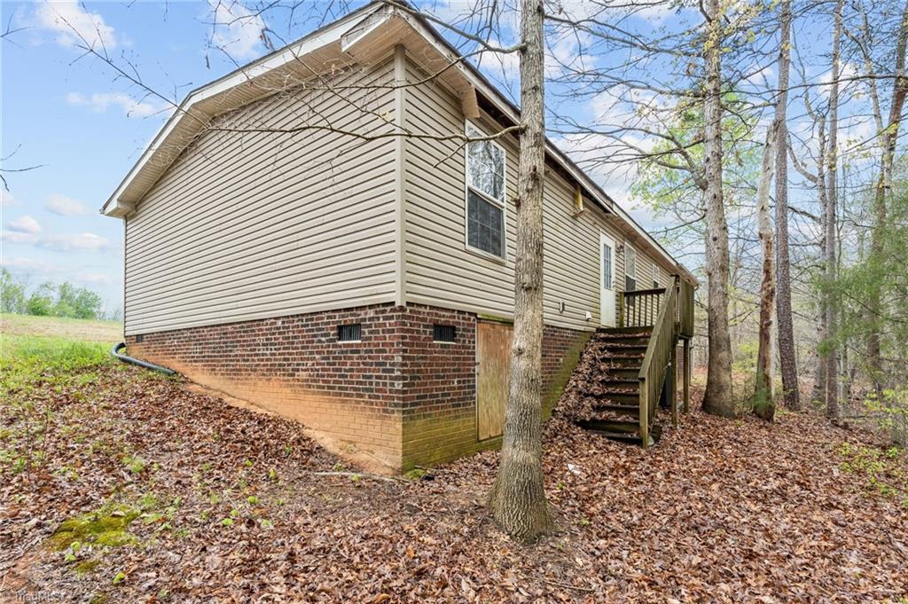 805 Sardis Church Road Madison, NC 27025 - Photo 27 of 38 Back exterior of the home showing the stairs to the backyard.