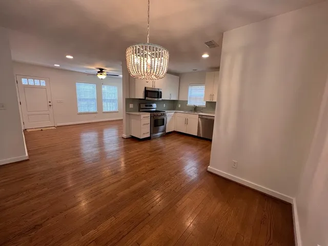 a view of a dining room with furniture wooden floor and chandelier