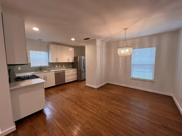 a view of kitchen with granite countertop stainless steel appliances and wooden floor
