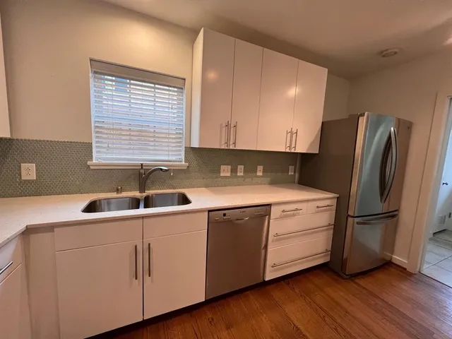 a kitchen with stainless steel appliances granite countertop a sink and a refrigerator