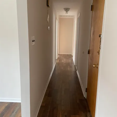a view of a hallway with wooden floor