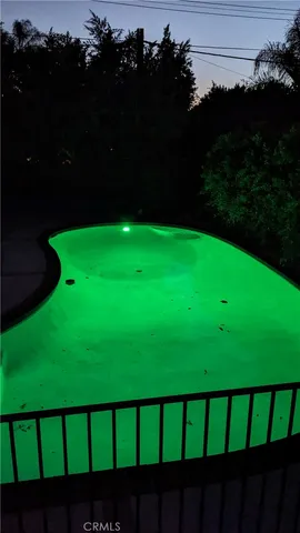 an empty room with wooden floor fireplace and windows