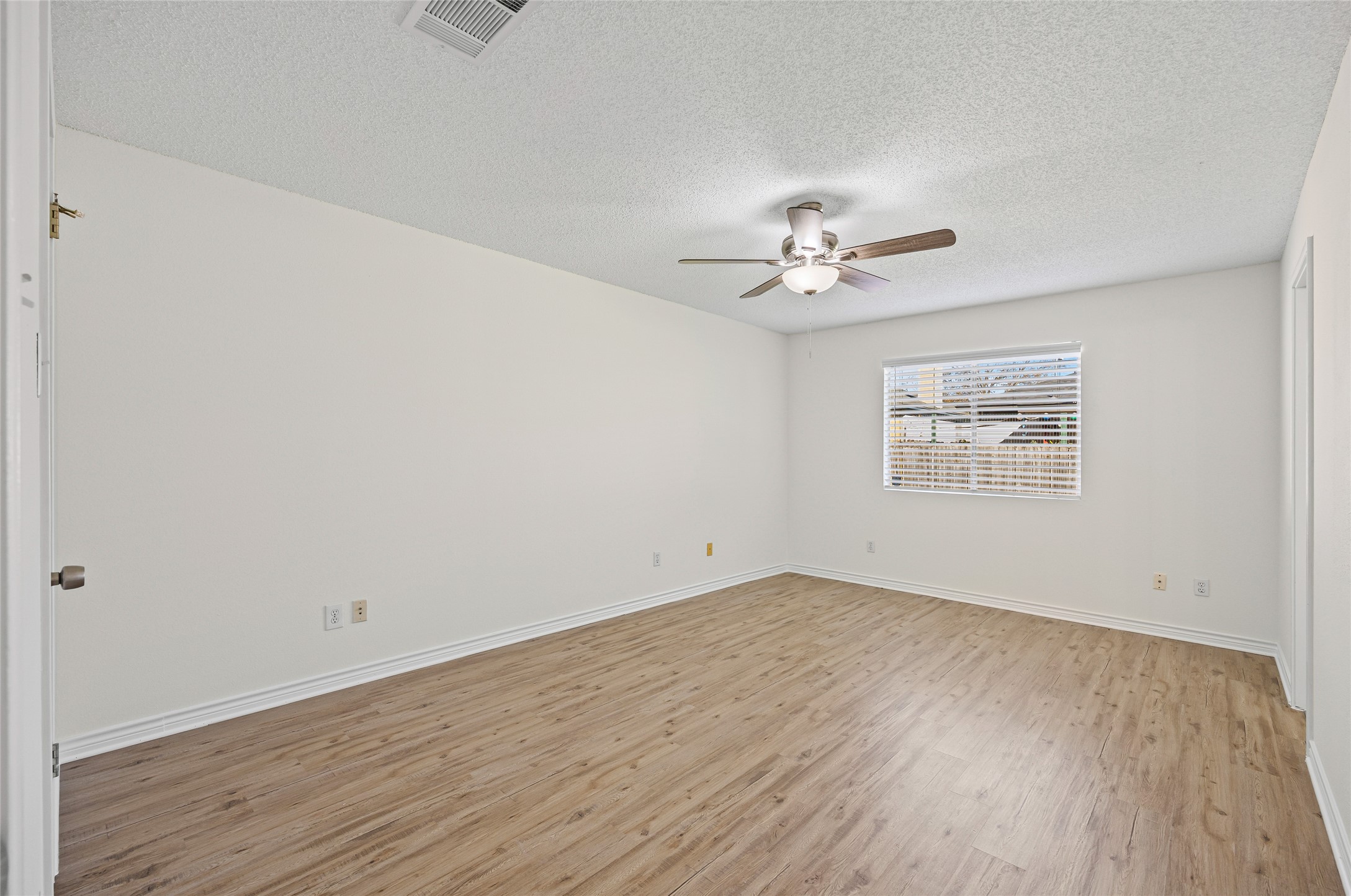 806 Calico Drive Austin, TX 78748 - Photo 18 of 25 Empty room with light wood-style flooring, a textured ceiling, and ceiling fan