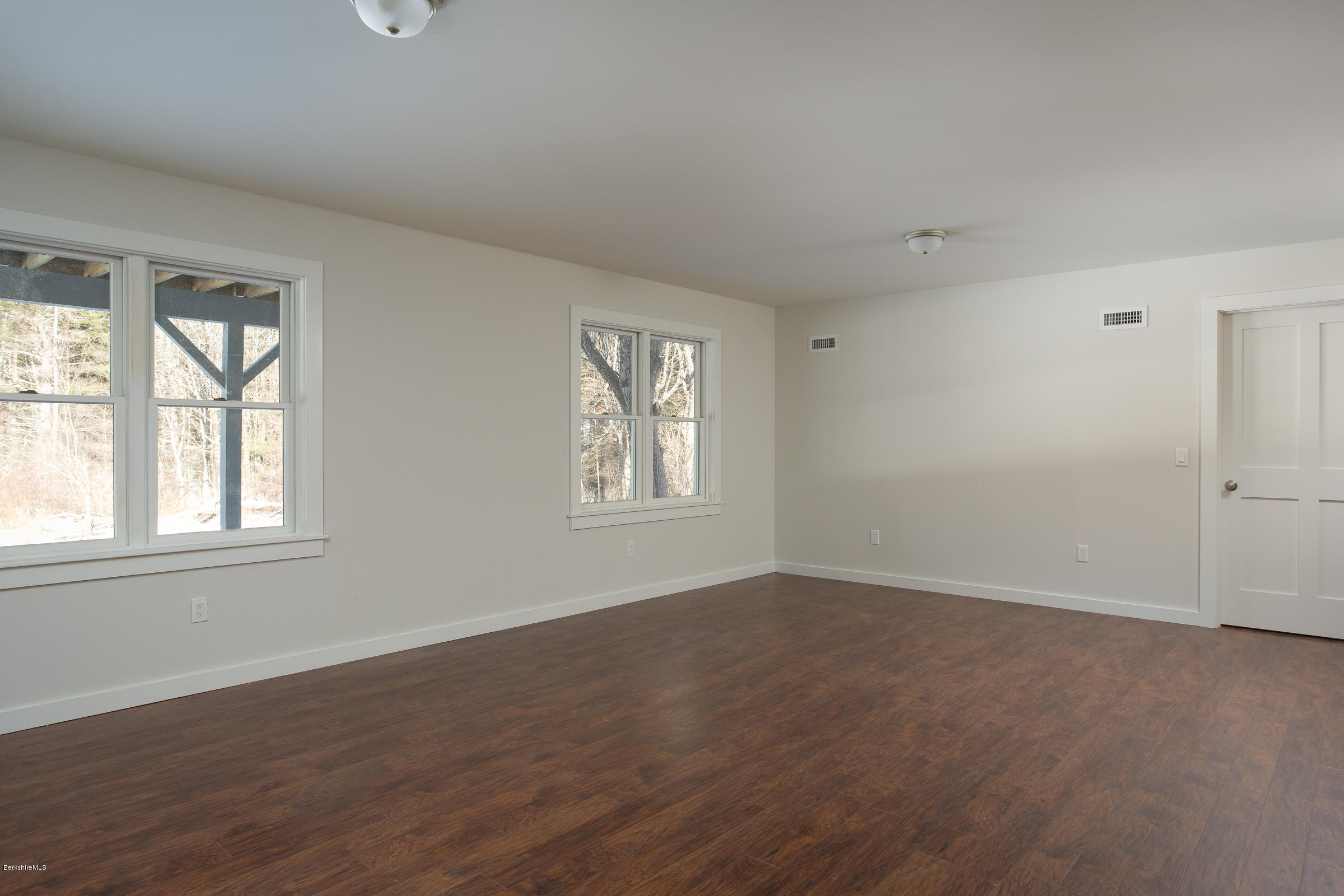 205 Main Road Monterey, MA 01245 - Photo 11 of 25 an empty room with wooden floor and windows