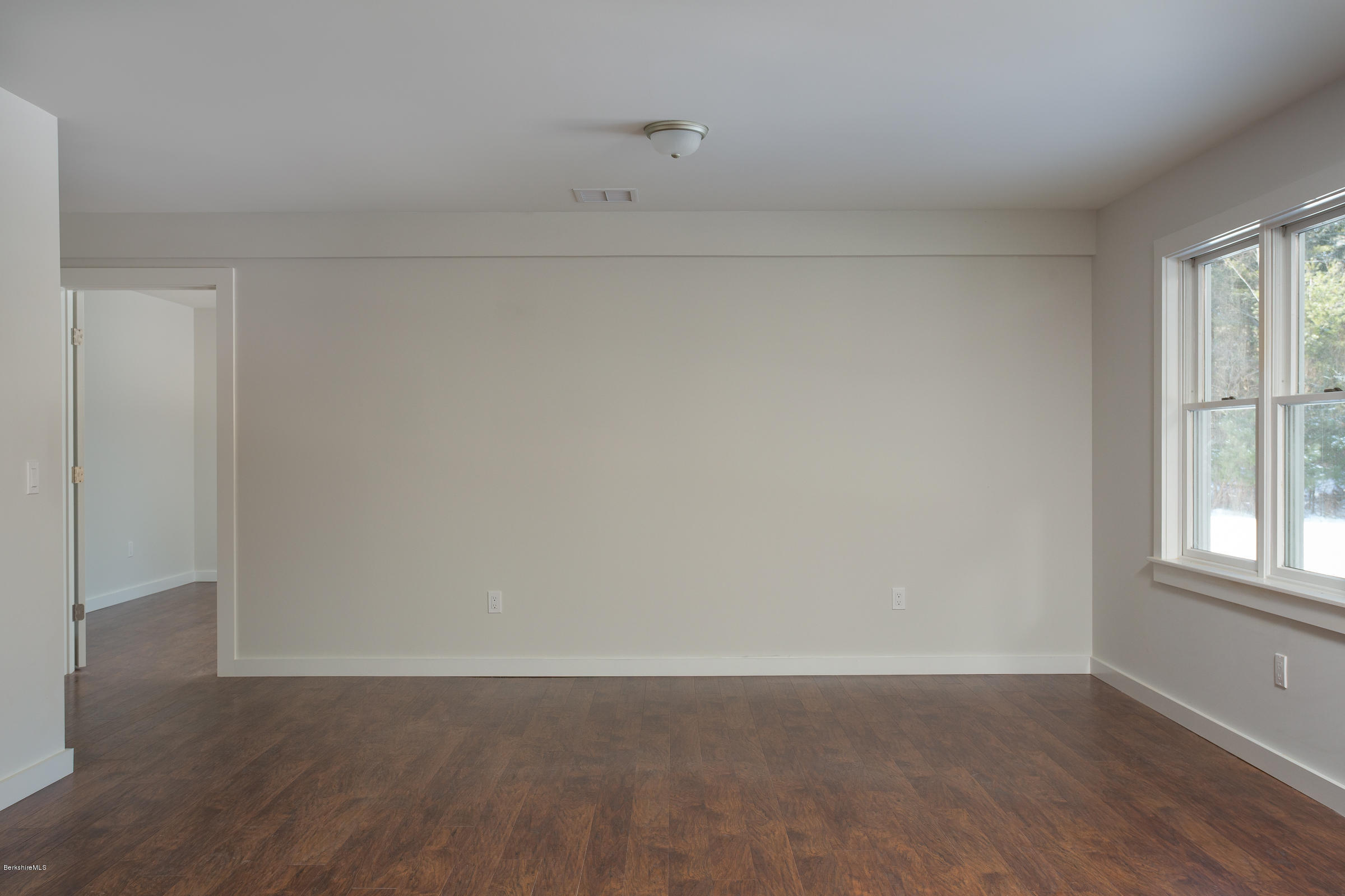 205 Main Road Monterey, MA 01245 - Photo 12 of 25 a view of an empty room with wooden floor and a window