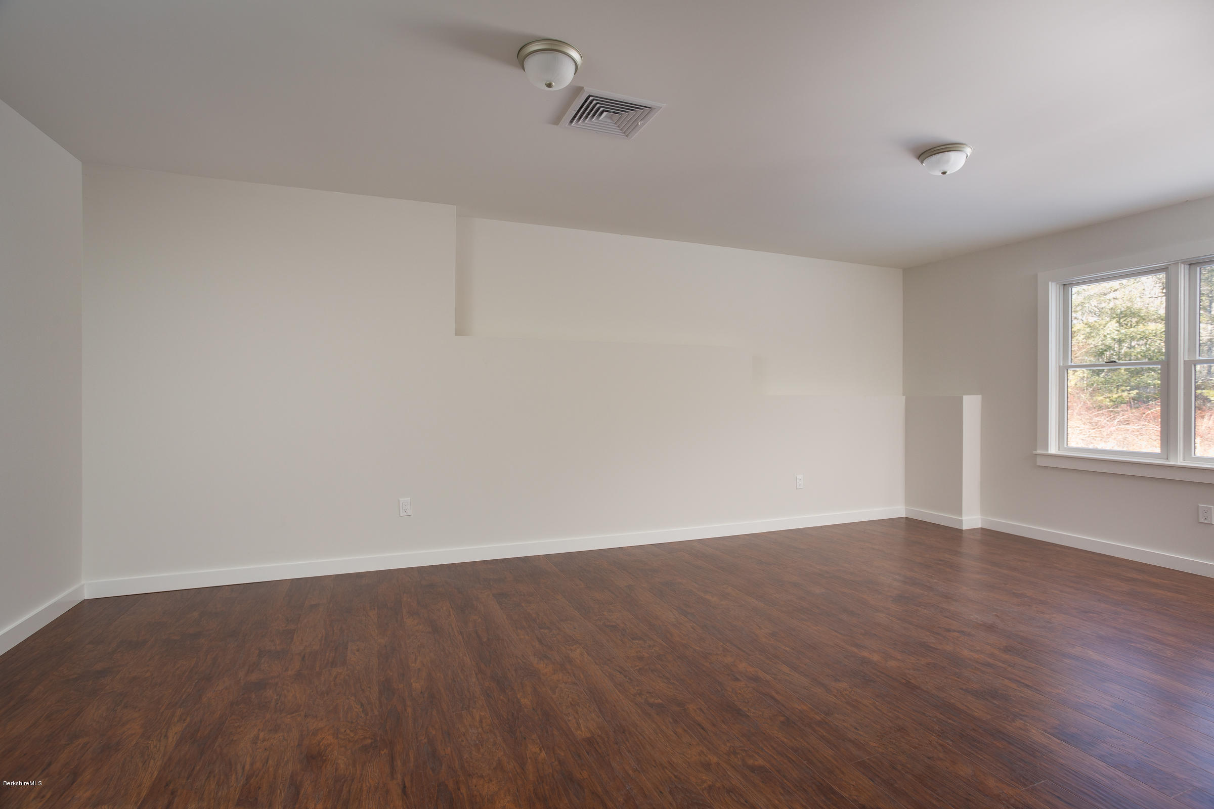 205 Main Road Monterey, MA 01245 - Photo 13 of 25 an empty room with wooden floor and windows