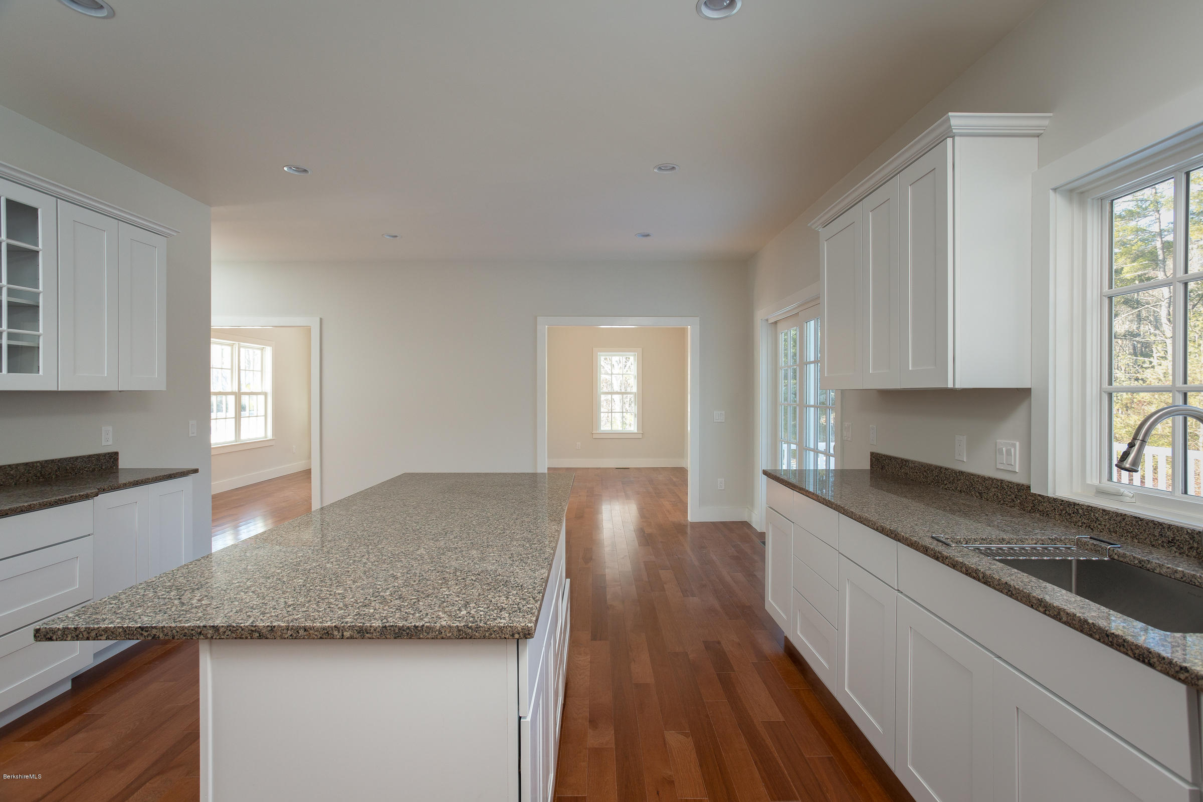 205 Main Road Monterey, MA 01245 - Photo 5 of 25 a large kitchen with granite countertop a stove a sink and white cabinets with wooden floor