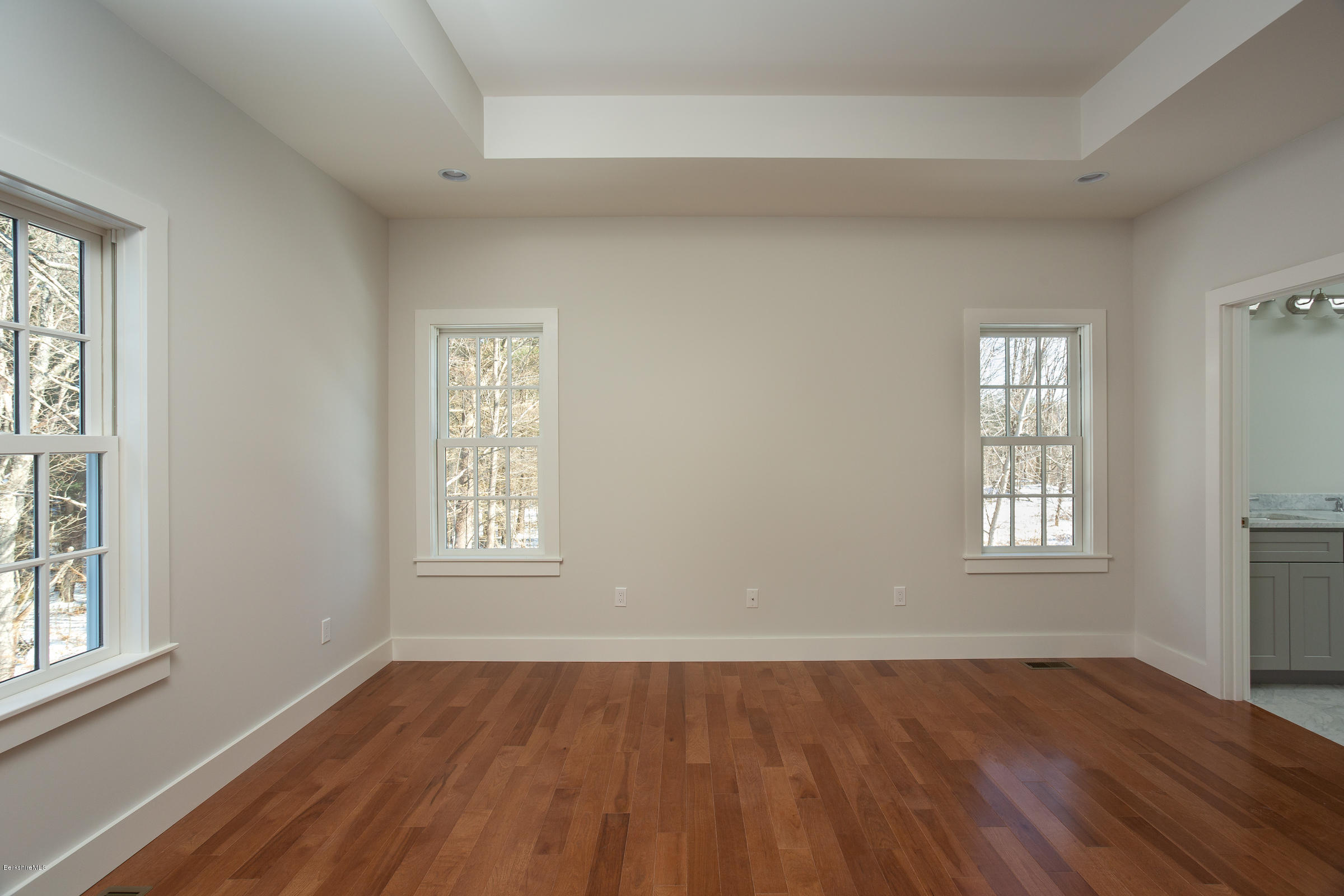 205 Main Road Monterey, MA 01245 - Photo 8 of 25 an empty room with wooden floor and windows