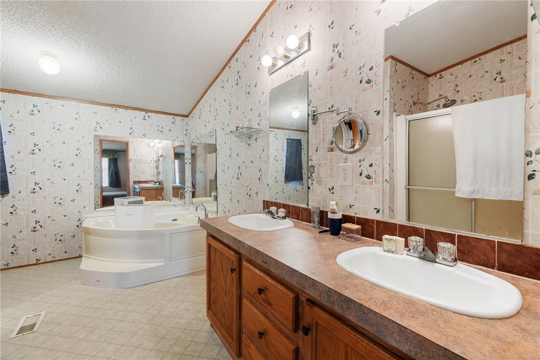 8277 Shady Lane Bryan, TX 77808 - Photo 12 of 21 a bathroom with a granite countertop double vanity sink mirror bathtub and shower