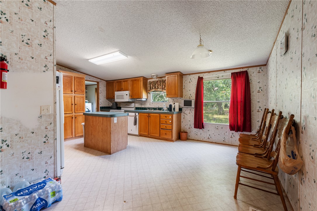 8277 Shady Lane Bryan, TX 77808 - Photo 6 of 21 a kitchen with stainless steel appliances kitchen island granite countertop a refrigerator a stove top oven a dining table and chairs with the bookshelf