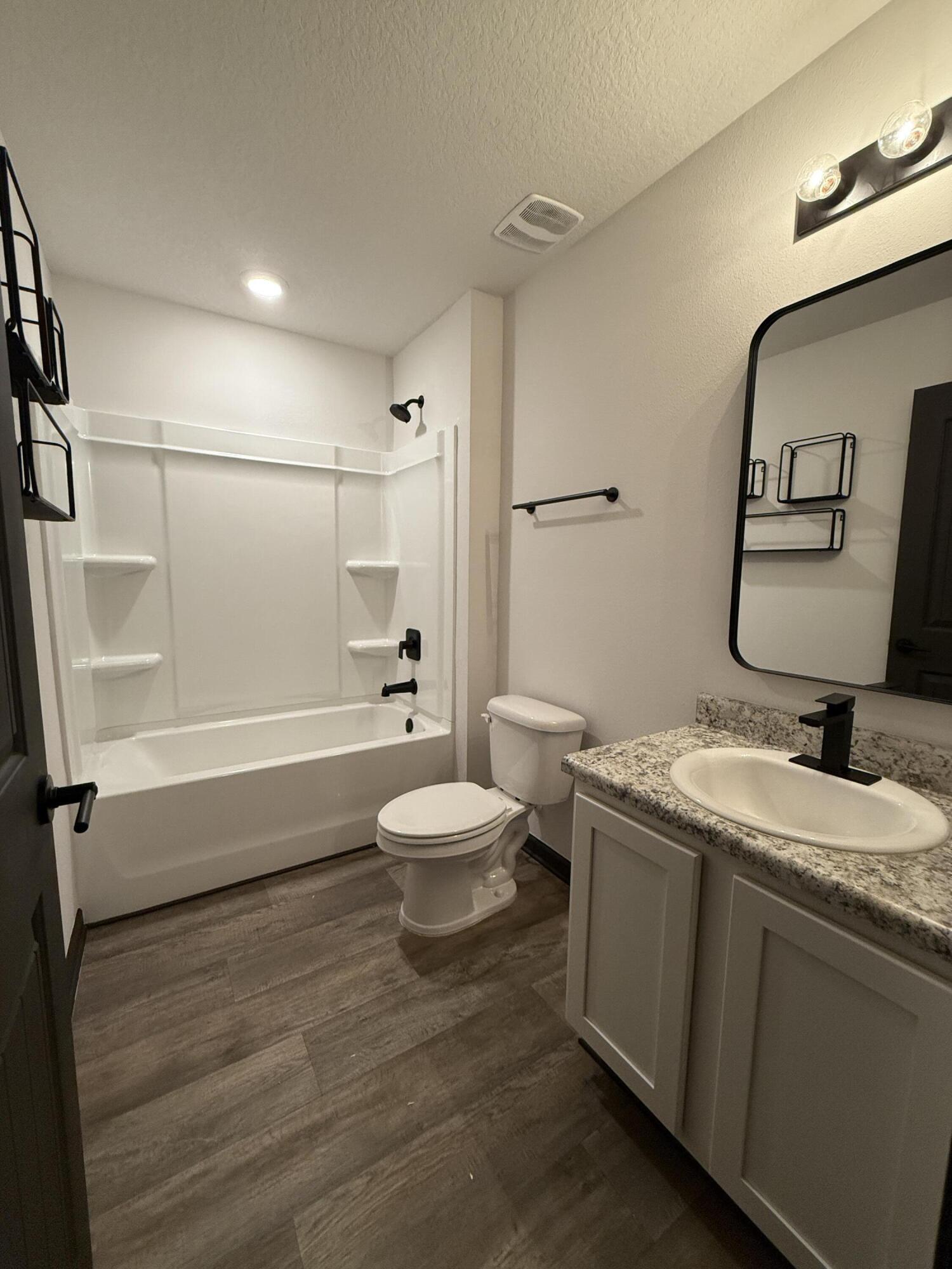 3476 Sparco Drive Crestview, FL 32539 - Photo 9 of 27 a bathroom with a granite countertop sink toilet a mirror and shower
