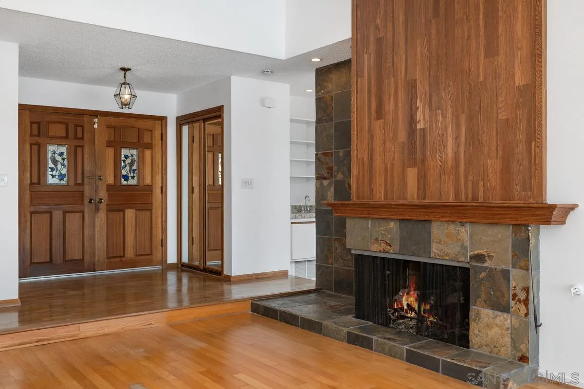 14186 Recuerdo Drive Del Mar, CA 92014 - Photo 14 of 35 a view of an empty room with wooden floor fireplace and a window