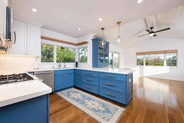 a kitchen with wooden floors and appliances