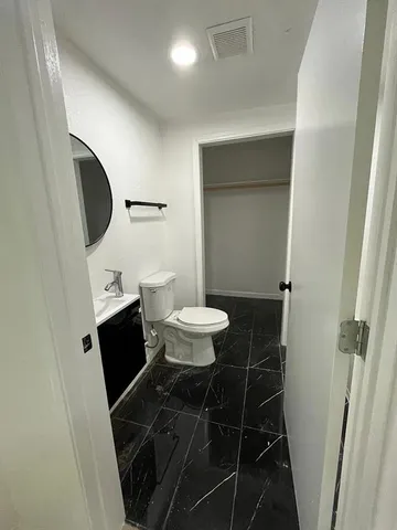 a bathroom with a toilet a sink and a mirror