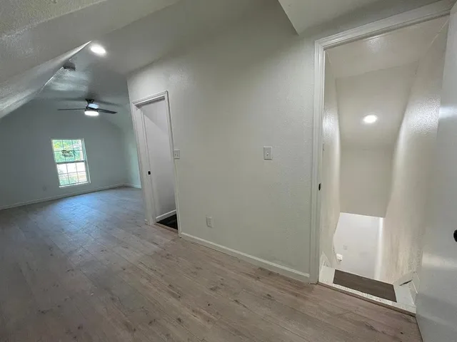 an empty room with wooden floor and mirror
