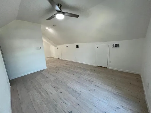 an empty room with wooden floor a ceiling fan and closet