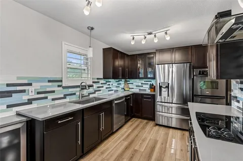 a kitchen with kitchen island granite countertop a sink stove and refrigerator