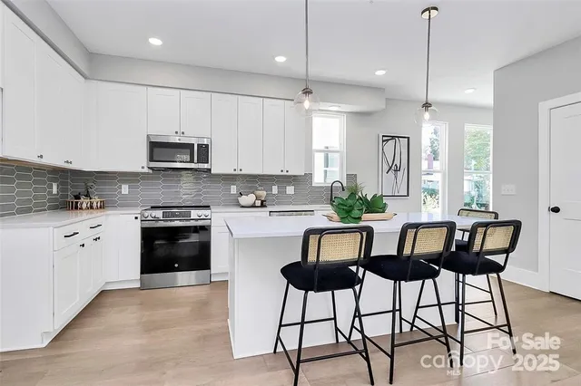 a kitchen with granite countertop white cabinets and stainless steel appliances