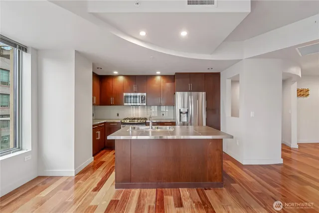 a kitchen with stainless steel appliances granite countertop a refrigerator a stove a sink a microwave and island