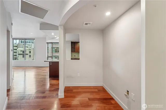 an empty room with wooden floor and windows