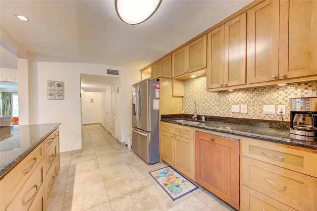a view of a white house with a large tree in front of it