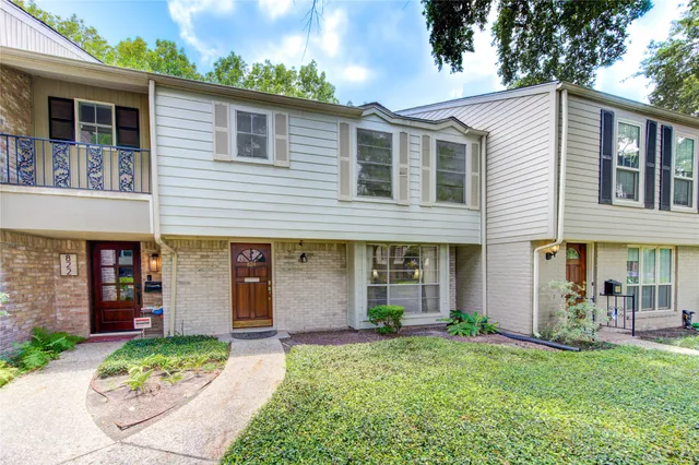 a front view of a house with a yard and trees