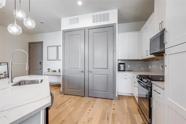 a kitchen with a sink cabinets stainless steel appliances and a counter top space
