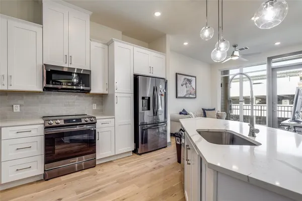 a kitchen with kitchen island granite countertop a refrigerator and a stove top oven