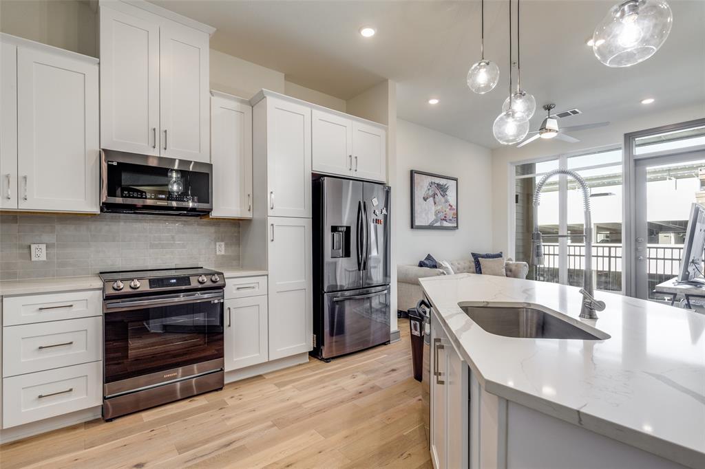 2700 Old Denton Road, Unit 3350 Carrollton, TX 75007 - Photo 5 of 12 a kitchen with kitchen island granite countertop a refrigerator and a stove top oven
