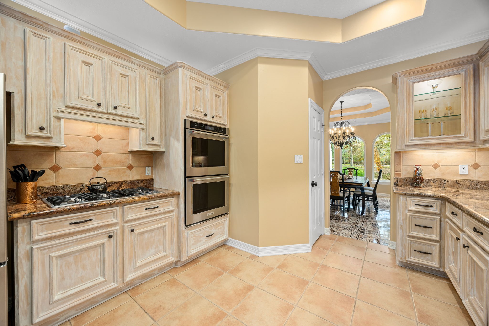 11984 White Oak Crossing Conroe, TX 77385 - Photo 18 of 42 Large kitchen with custom cabinet finish, granite counter tops, stainless steel appliances and bar area, great flow into the dining room and living room