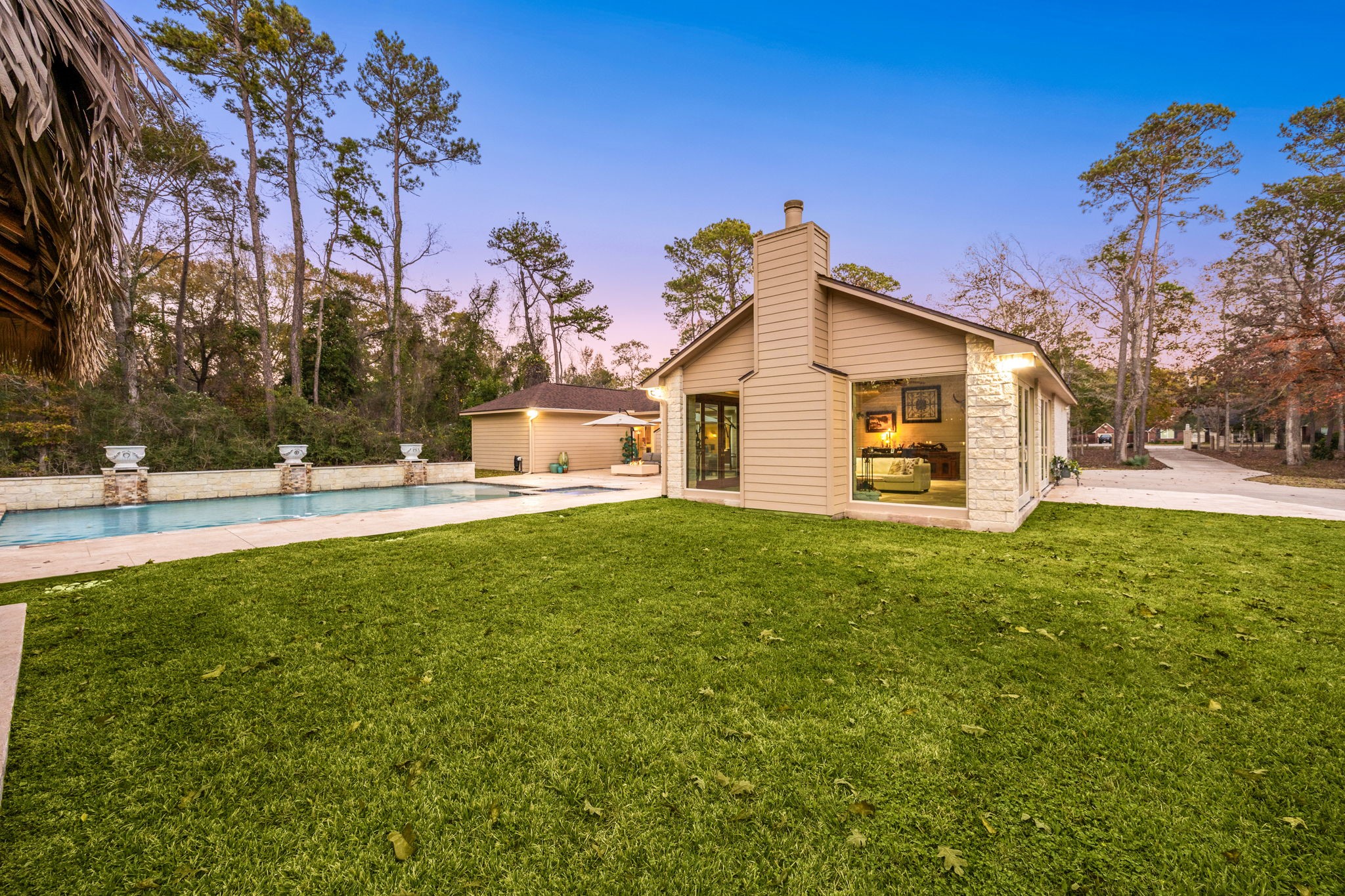 11984 White Oak Crossing Conroe, TX 77385 - Photo 4 of 42 View of the massive air conditioned sunroom and modern style pool with hot tub, waterfall feature, gas fire pit and lounge area
