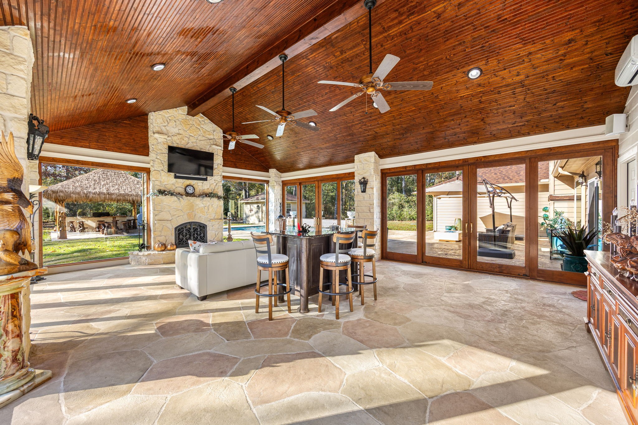 11984 White Oak Crossing Conroe, TX 77385 - Photo 7 of 42 Fully enclosed, air-conditioned sunroom with Pella sliding doors and easy access to the pool, outdoor seating and firepit and theater room