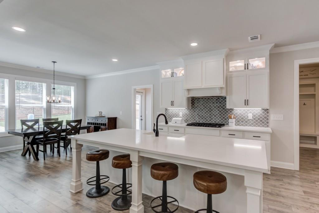 525 Storey Lane Jefferson, GA 30549 - Photo 14 of 45 a kitchen with stainless steel appliances granite countertop a dining table chairs stove and white cabinets