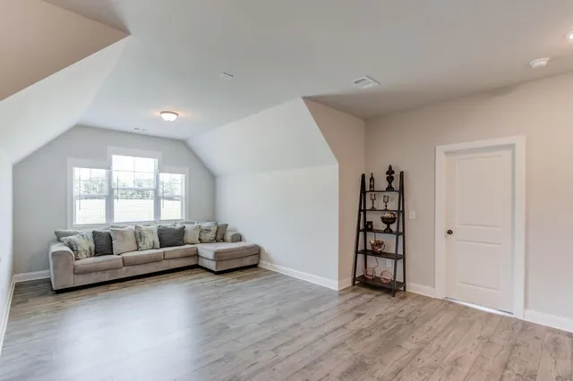 a view of a room with wooden floor and a ceiling fan