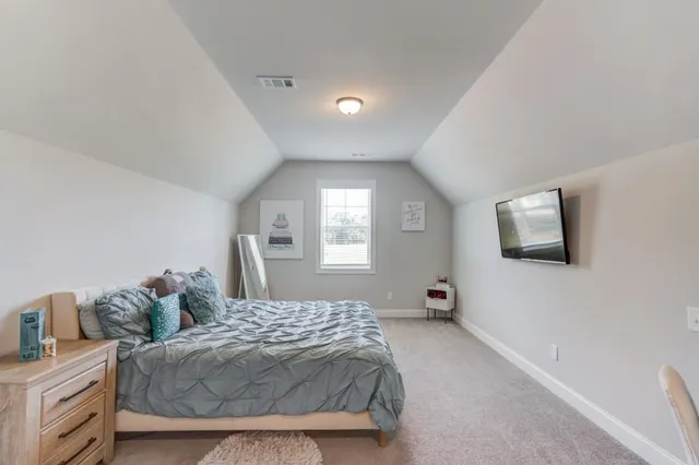 a spacious bedroom with a bed and chair