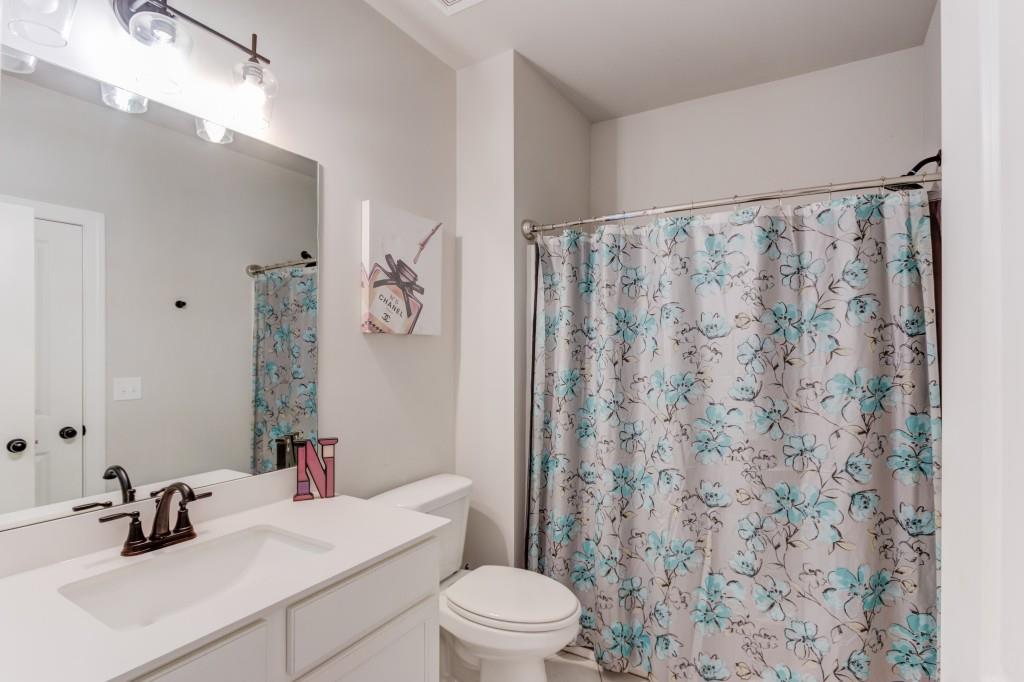 525 Storey Lane Jefferson, GA 30549 - Photo 34 of 45 a bathroom with a sink a toilet a mirror and shower curtain