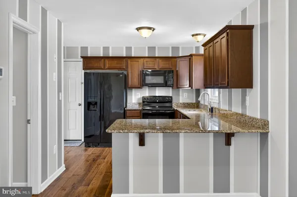 a kitchen with granite countertop a sink stove and refrigerator