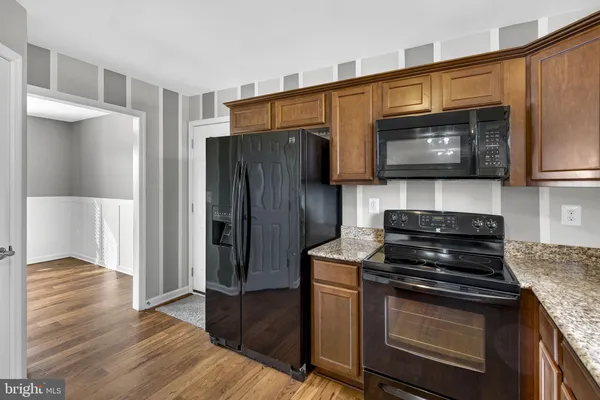 a kitchen with granite countertop wooden cabinets and stainless steel appliances
