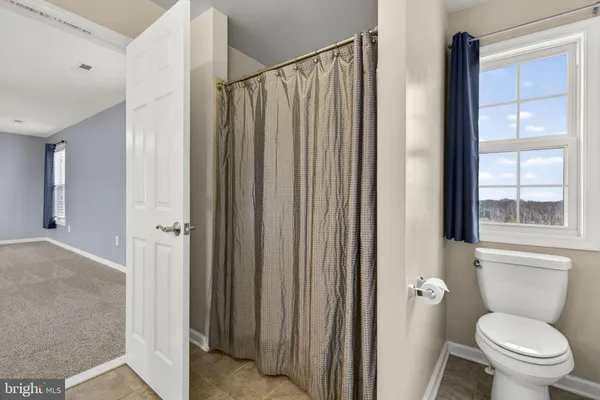 a bathroom with a toilet and a shower