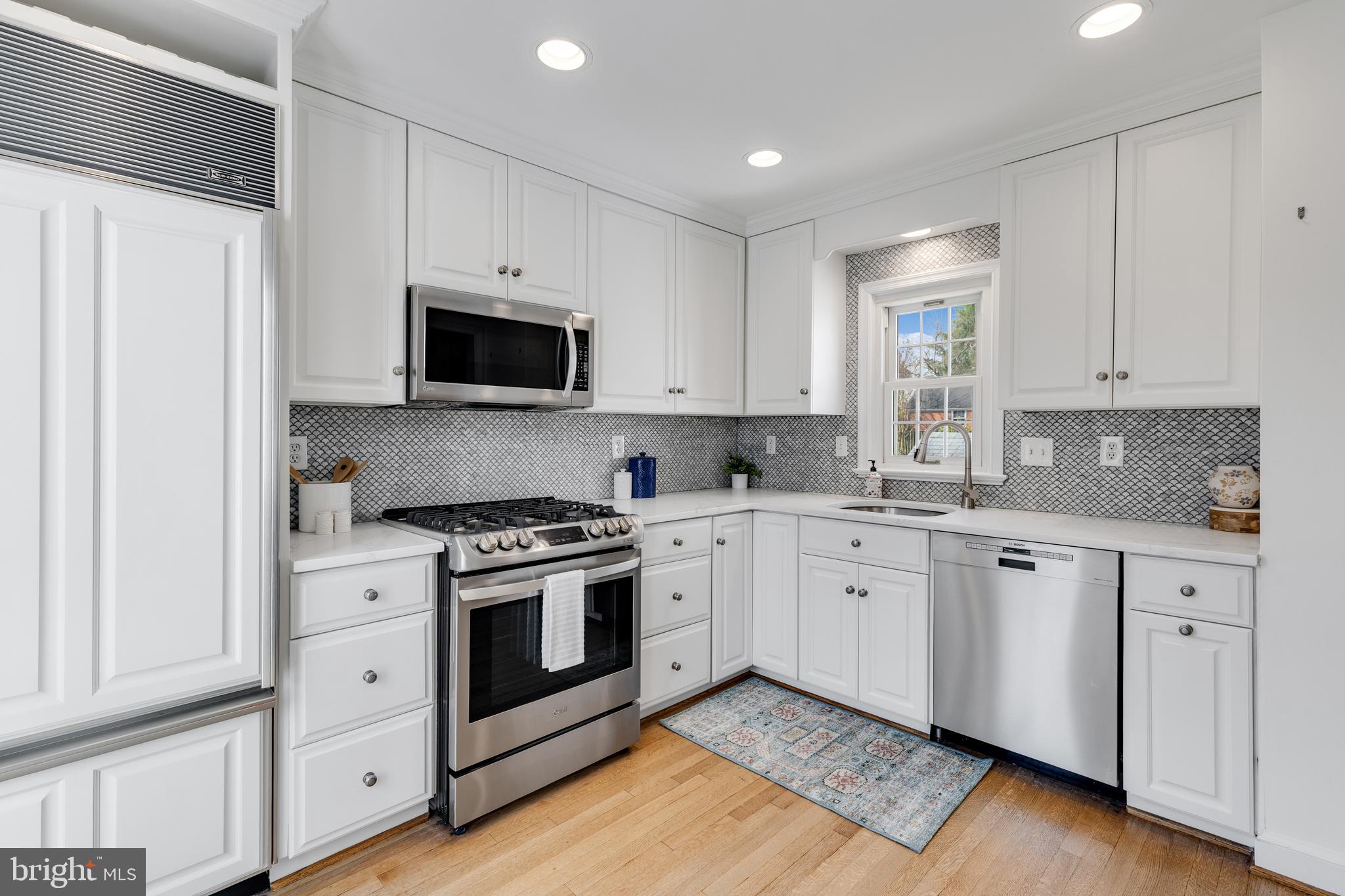 314 Whitestone Road Silver Spring, MD 20901 - Photo 13 of 36 a kitchen with granite countertop white cabinets and white appliances
