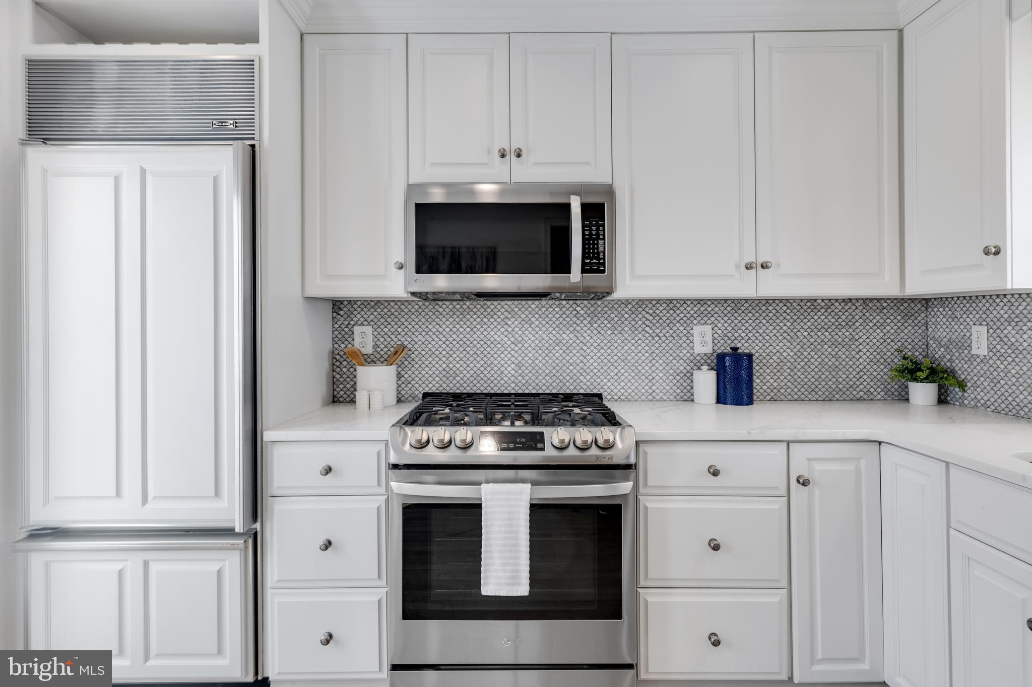 314 Whitestone Road Silver Spring, MD 20901 - Photo 14 of 36 a kitchen with white cabinets and stainless steel appliances