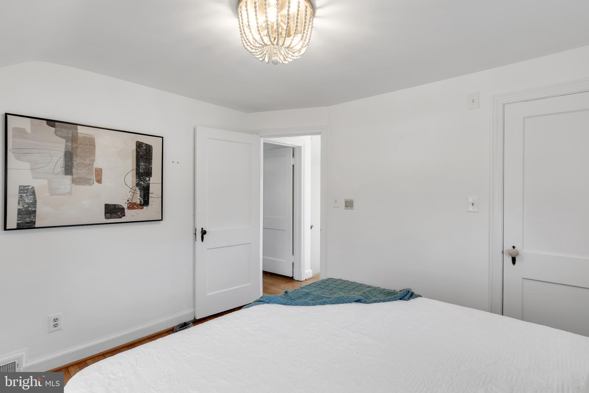 314 Whitestone Road Silver Spring, MD 20901 - Photo 26 of 36 a bedroom with a bed and a chandelier