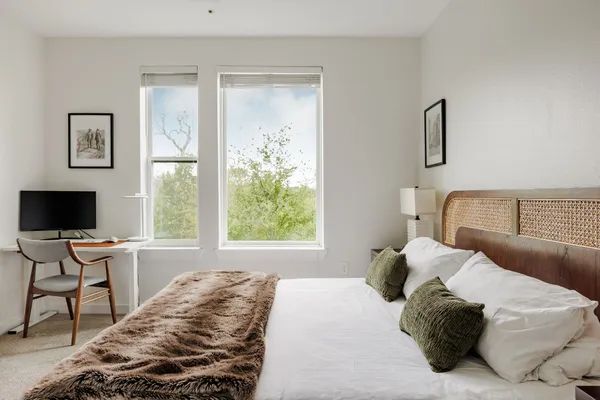 a bedroom with a bed and a flat tv screen on the dresser