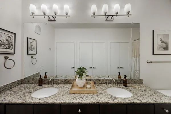 a bathroom with double vanity sinks and a mirror