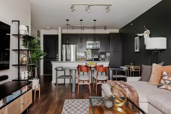 a kitchen with stainless steel appliances kitchen island granite countertop a table chairs and a refrigerator
