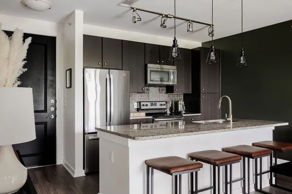 a kitchen with stainless steel appliances granite countertop a sink refrigerator and cabinets