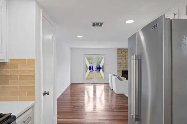 a view of hallway with wooden floor and cabinets