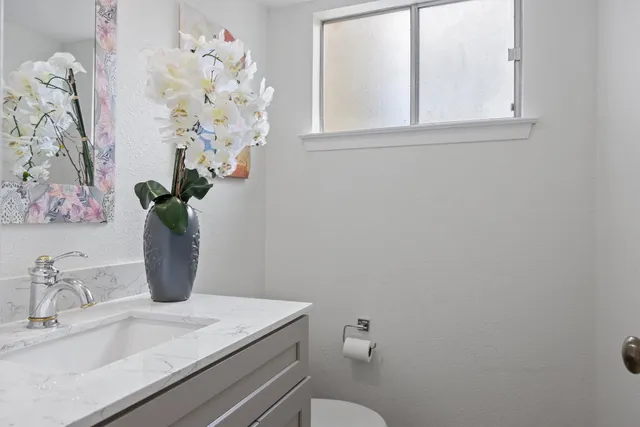 a bathroom with a sink a toilet and a mirror