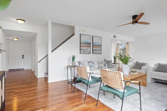 a living room with furniture and a wooden floor